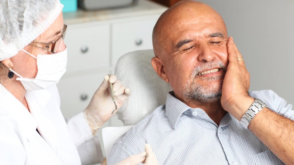 Adulto mayor con dolor recibiendo atención odontológica de urgencia en cuarentena